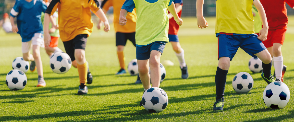 Kinder trainieren jeweils mit einem Fußball