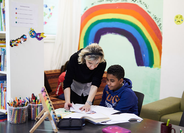 Edita hilft einem Buben von den Büffelböcken bei der Hausübung