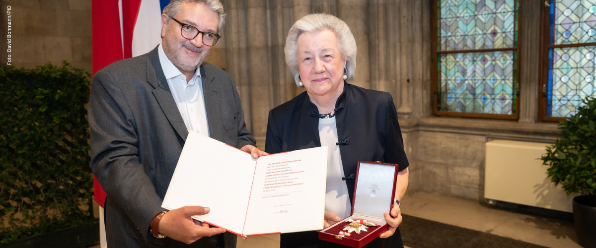Stadtrat Peter Hacker übergibt Christl Weinberger die Urkunde zum Silbernen Ehrenzeichen