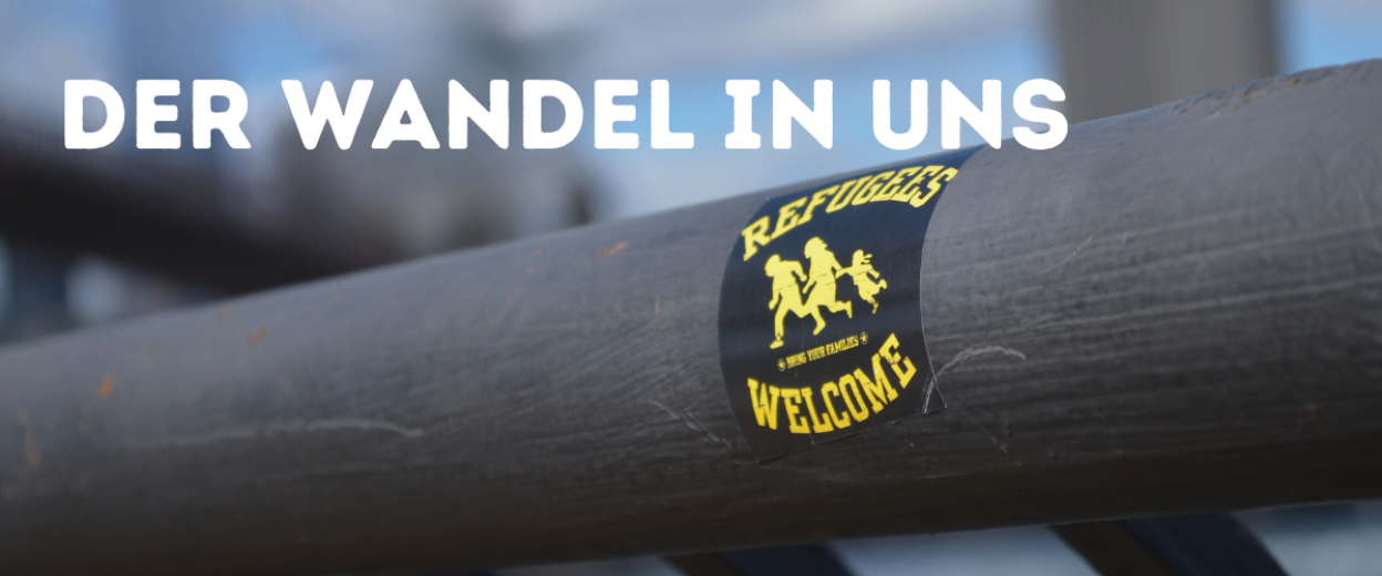 Der Wandel in uns - Schriftzug über dem Sticker mit "Refugees Welcome"