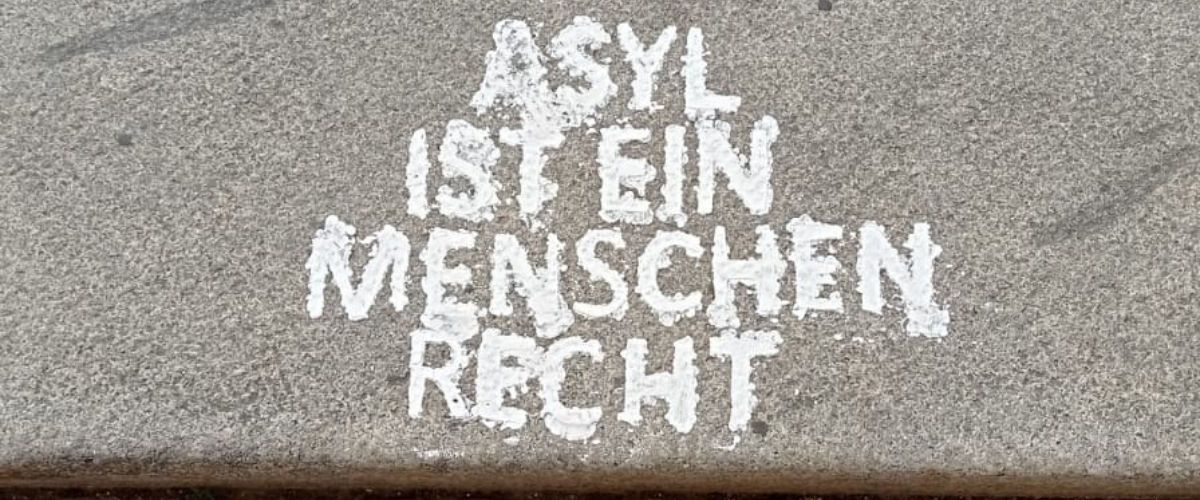 Asyl ist ein Menschenrecht - geschrieben in Kreide auf Gehsteig