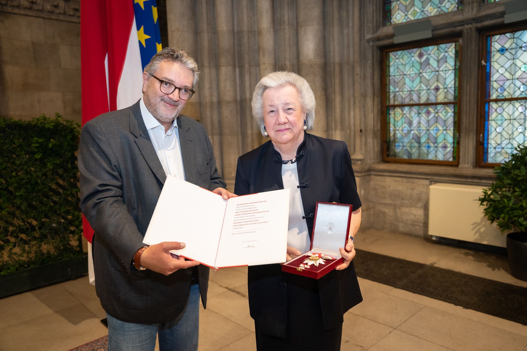 Stadtrat Peter Hacker übergibt Christl Weinberger die Urkunde zum Silbernen Ehrenzeichen