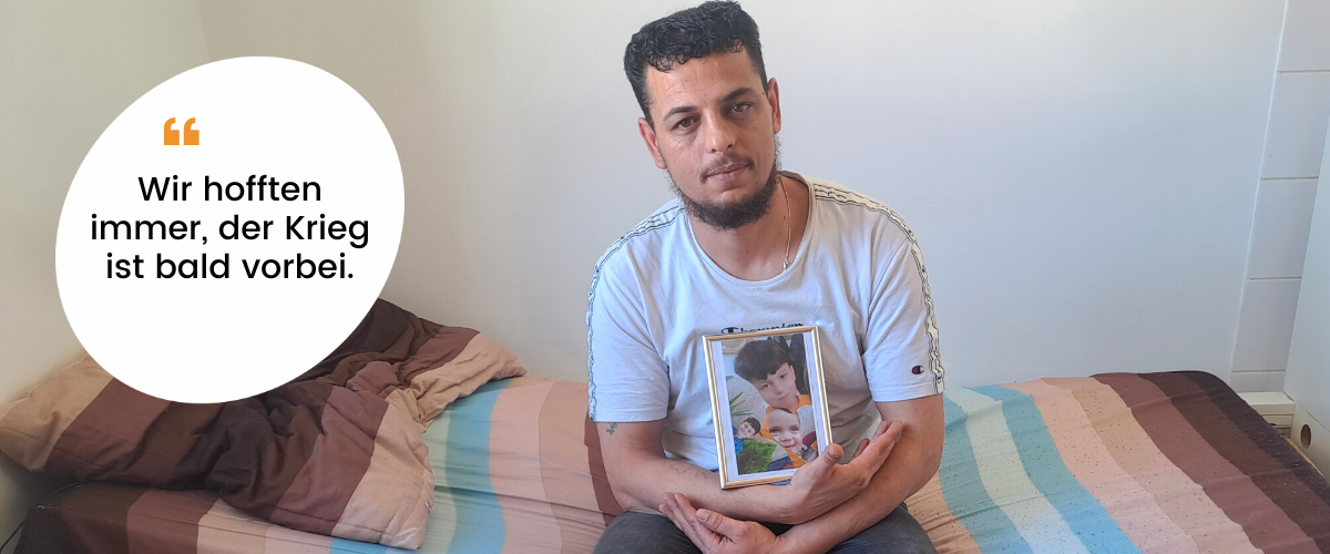 Aadil sitzt mit einem Foto seiner drei Kinder auf seinem Bett im Ute Bock Haus, daneben eine Sprechblase mit "Wir hofften immer, der Krieg ist bald vorbei."