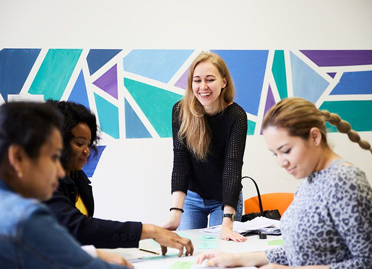 Eine ehrenamtliche Deutschlehrerin mit ihren Schülerinnen im Deutschkurs