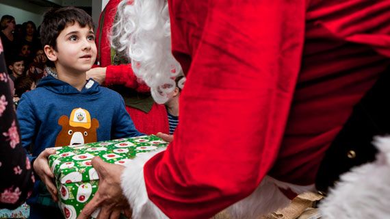 Bub bekommt Geschenk vom Weihnachtsmann beim Ute Bock Winterfest