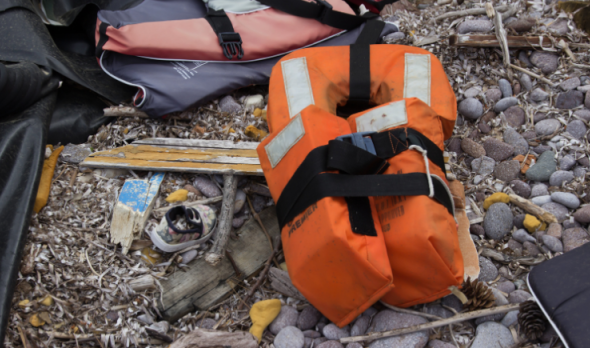 Angespülte Rettungsweste und Habseligkeiten, wie ein Kinderschuh, von einem gesunkenen Flüchtlingsboot