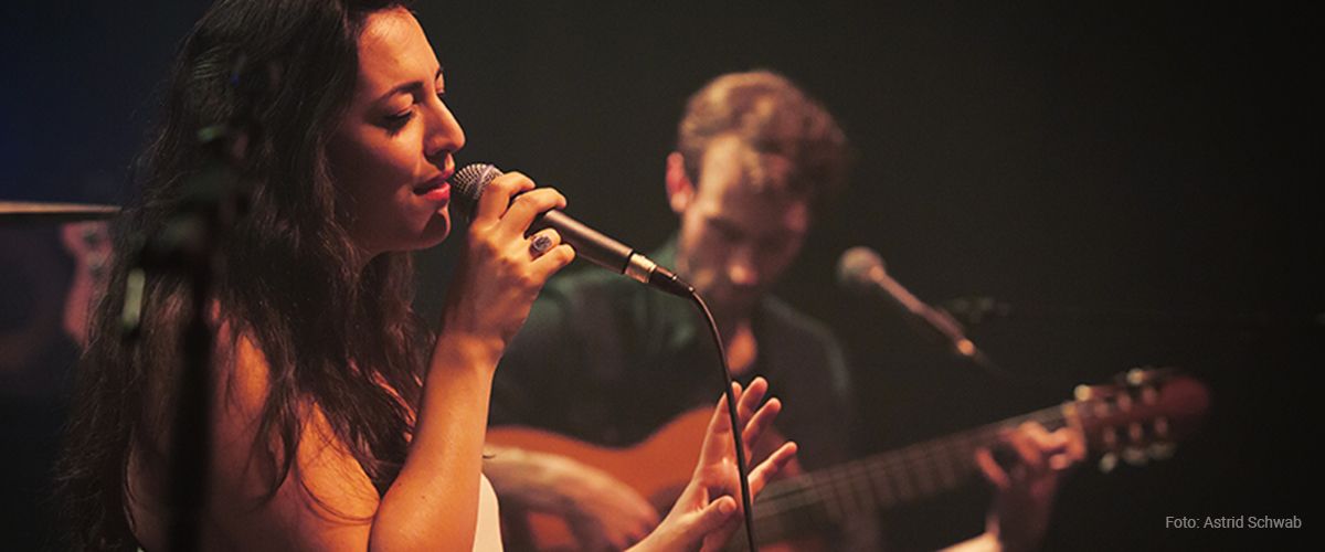 Sängerin im Vordergrund, Gitarrenspieler im Hintergrund