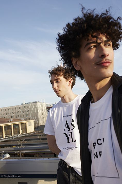 zwei junge Männer in Bock Shirts vor Stadtkulisse
