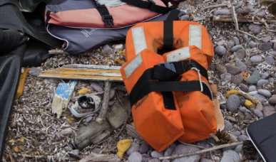 Angespülte Rettungsweste und Habseligkeiten, wie ein Kinderschuh, von einem gesunkenen Flüchtlingsboot