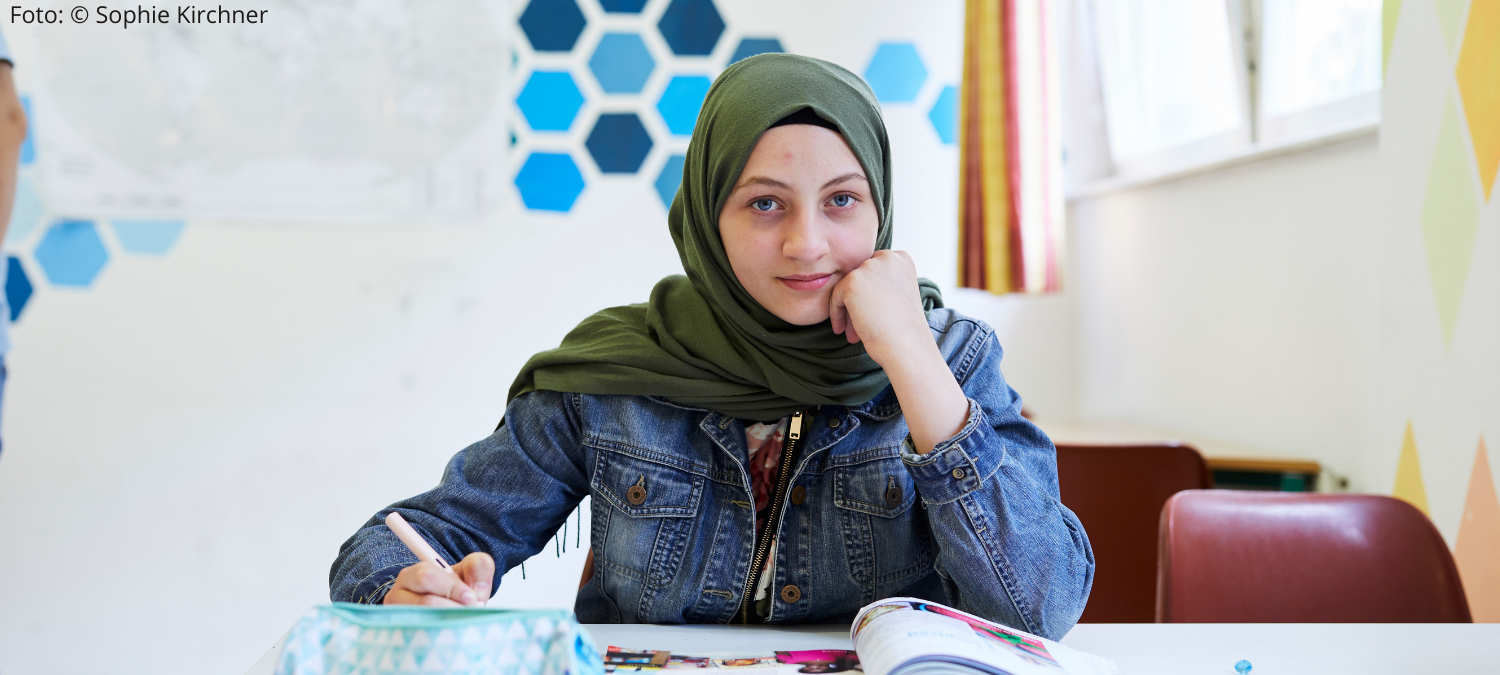 Ein Maedchen mit Hijab schreibt ihre Hausuebung 