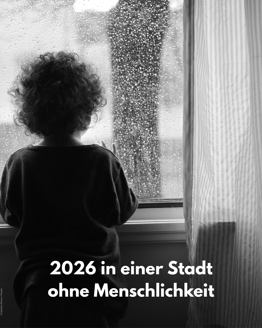 Kleinkind steht vor Fenster - Kürzungen treffen Alleinerziehende
