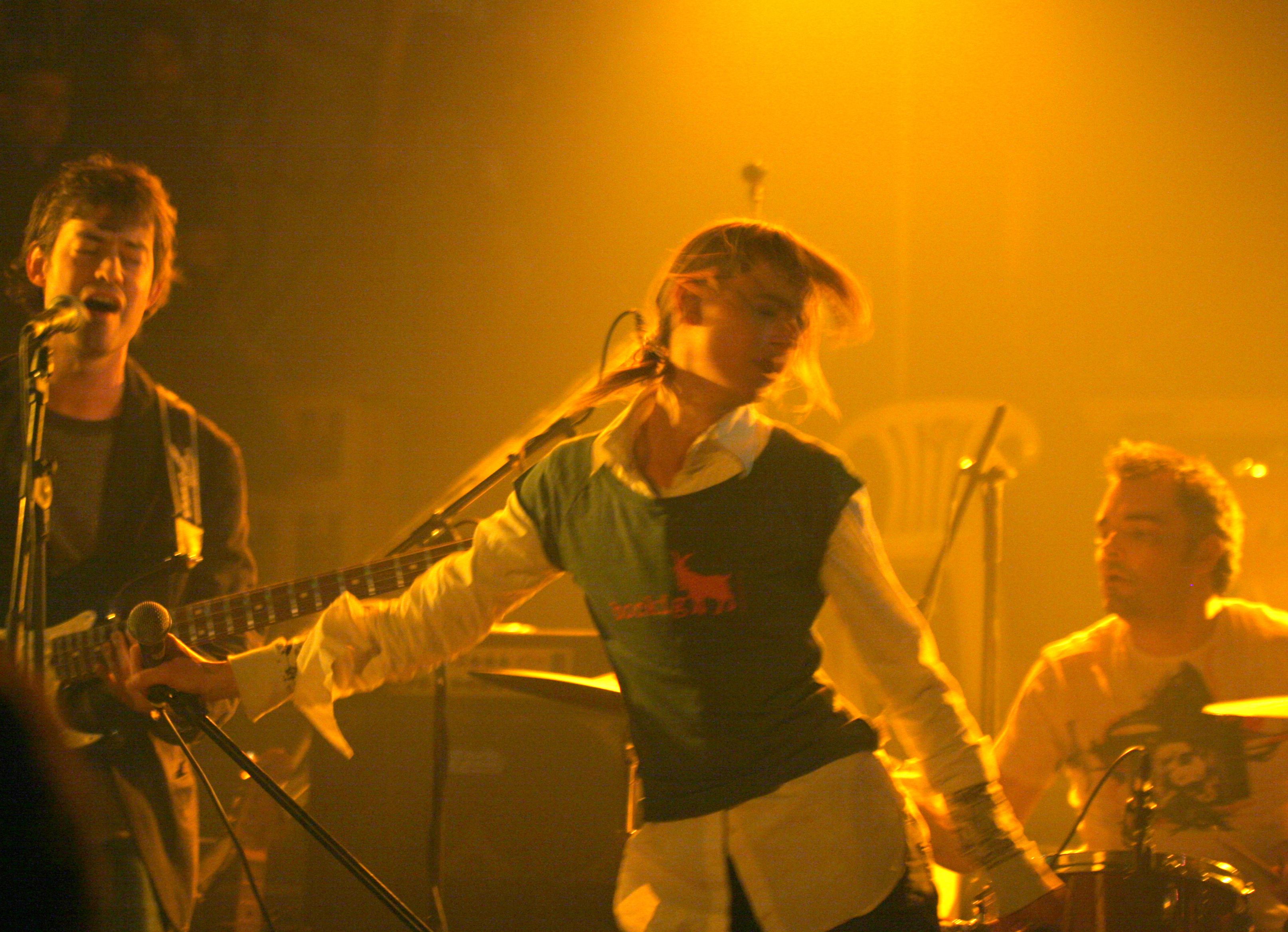 Sängerin im bockig Shirt mit Band auf Bühne